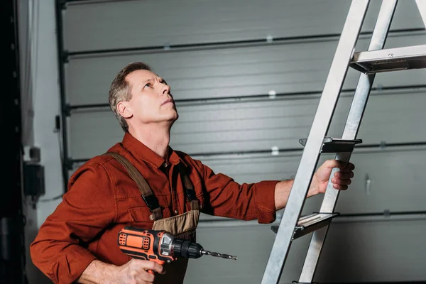 Reparateur Klettert Mit Schraubenzieher Auf Leiter Garage — Stockfoto