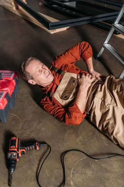 Middle Aged Repairman Lying Floor Ladder Holding Side Garage — Stock Photo, Image