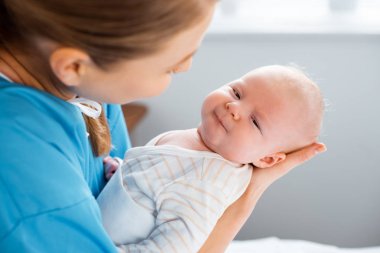 Genç Anne hastane odasında taşıma bebek kadeh kırpılmış