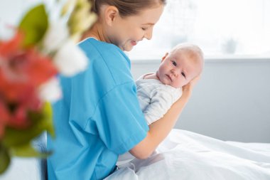 mutlu genç anne holding bebek hastane odasında seçici odak