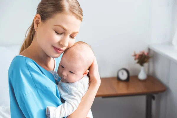 Happy Young Mother Closed Eyes Carrying Adorable Baby Hospital Room — Stock Photo, Image