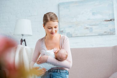 kanepe ve emzirme, bebek üzerinde oturan güzel gülümseyen Genç Anne