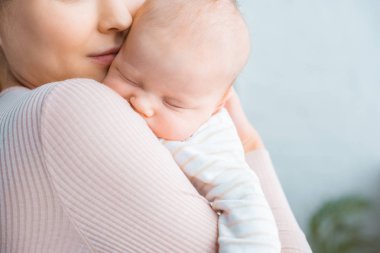 Genç Anne taşıyan çok güzel uyuyan bebek kadeh kırpılmış 