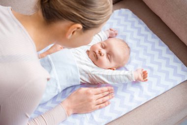 Genç Anne Bebek bebek koltukta yalan bakarak yüksek açılı görünüş