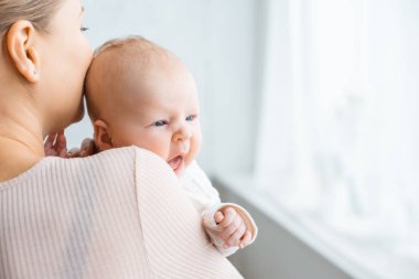 Genç Anne yeni doğan bebek evde öpüşme fotoğrafını kırpılmış