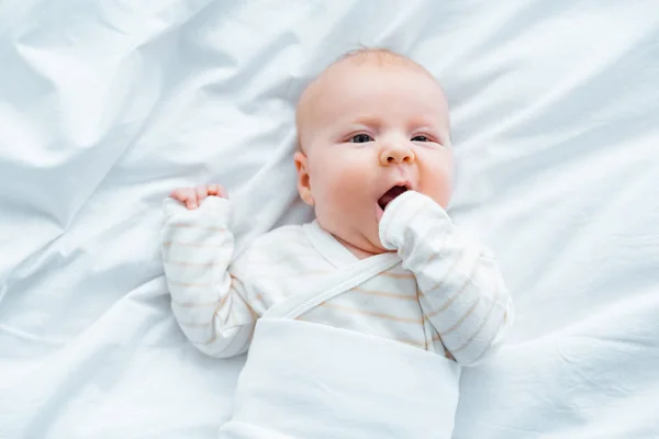 Draufsicht Auf Entzückendes Baby Das Auf Weißem Bettzeug Liegt — Stockfoto