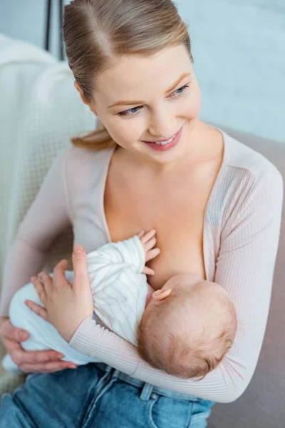 Happy Young Woman Breastfeeding Infant Daughter Looking Away Home — Stock Photo, Image