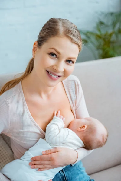 Glückliche Junge Mutter Stillt Baby Und Lächelt Die Kamera — Stockfoto