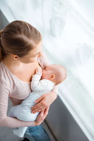 Genç Anne Emzirme Bebek Penceresine Bakarak Yüksek Açılı Görünüş — Stok fotoğraf