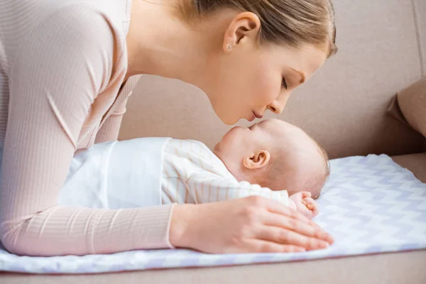 Side View Happy Young Mother Kissing Adorable Child Lying Couch — Stock Photo, Image