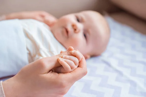 Cropped Shot Mother Holding Hand Adorable Infant Kid Lying Couch — Stock Photo, Image