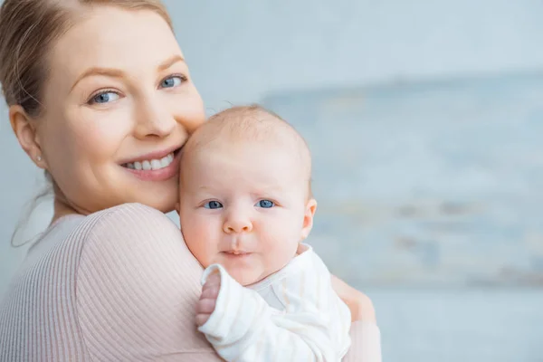 Feliz Joven Madre Llevando Adorable Bebé Sonriendo Cámara —  Fotos de Stock