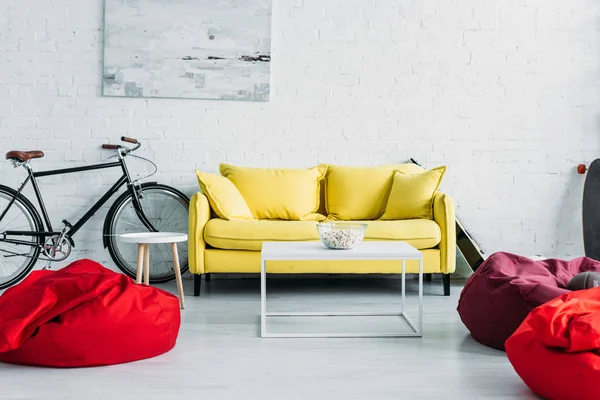 宽敞的客厅配有舒适的豆袋椅和舒适的黄色沙发 — 图库照片