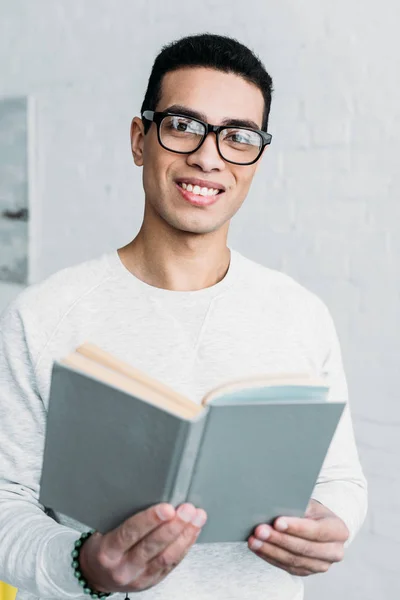 Lachende Gemengd Ras Jongeman Glazen Boek Houden Kijken Naar Camera — Stockfoto