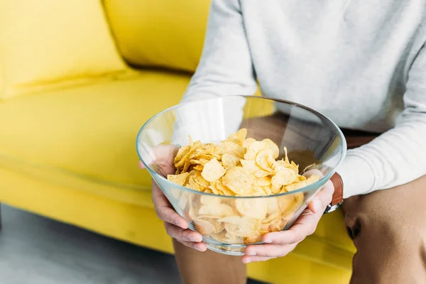 Partial View Man Sitting Yellow Sofa Holding Bowl Chips — Stock Photo, Image