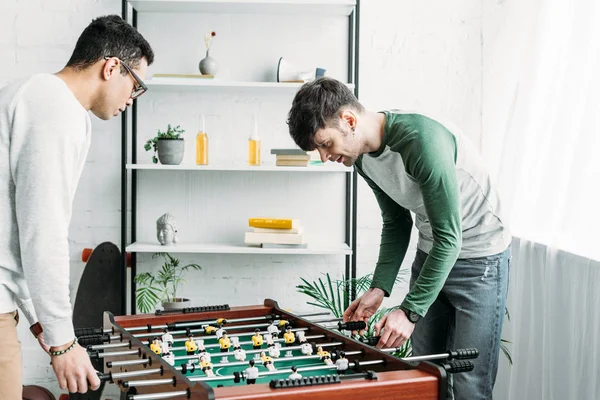 Amigos Multiculturais Bonitos Jogando Futebol Mesa Sala Estar — Fotografia de Stock