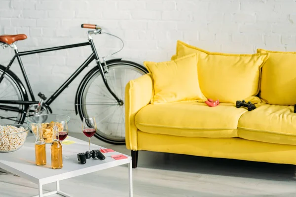 Living with comfortable yellow sofa and table with drinks and snacks — Stock Image Living Comfortable Yellow Sofa Table Drinks Snacks Royalty Free Stock Photos
