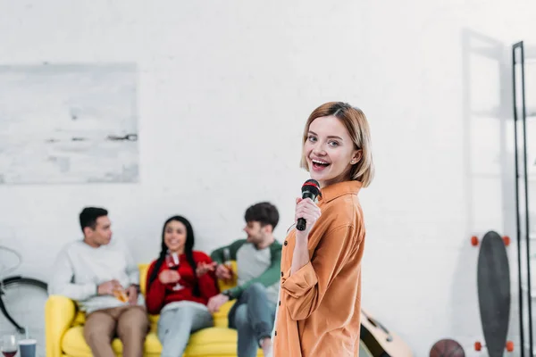 Pretty Girl Singing Karaoke While Multiethnic Friends Enjoying Drinks Yellow — Stock Photo, Image