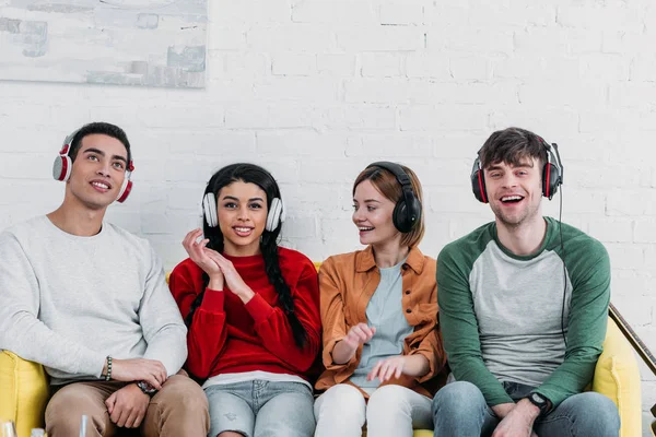 Multiculturele Luisteren Muziek Met Koptelefoon Zittend Gele Bank — Stockfoto