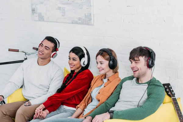 Multiethnic Friends Listening Music Headphones While Sitting Yellow Sofa Living — Stock Photo, Image