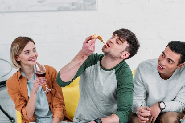 Handsome Young Man Eating Pizza Sitting While Multicultural Friends Enjoying — Stock Photo, Image
