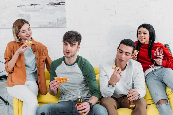 Amigos Multiculturais Felizes Comendo Pizza Desfrutando Bebidas Enquanto Sentados Juntos — Fotografia de Stock