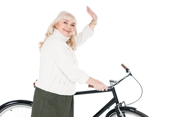 Alegre Sénior Mujer Saludando Mano Cerca Bicicleta Aislado Blanco — Foto de Stock