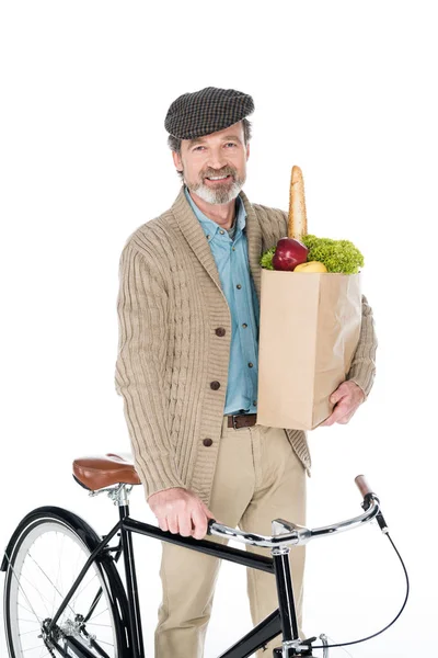 快乐的退休老人微笑整个囤积纸袋与杂货和自行车隔离在白色 — 图库照片