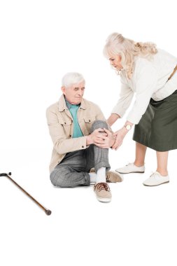 senior man holding knee while having arthritis pain near caring wife isolated on white clipart