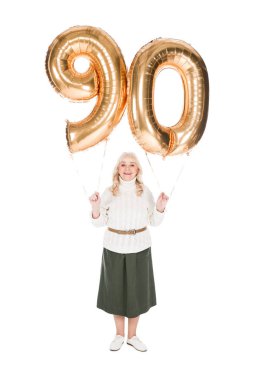 90 altın balon üzerinde beyaz izole tutan neşeli üst düzey kadın