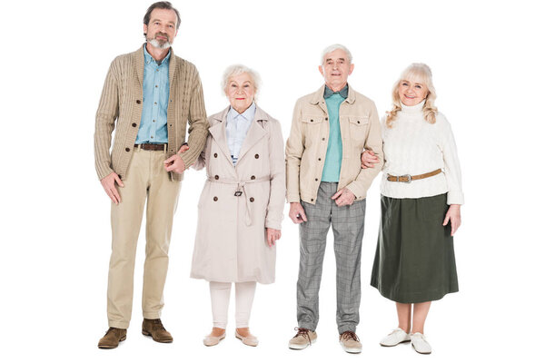 cheerful retired people standing and smiling isolated on white