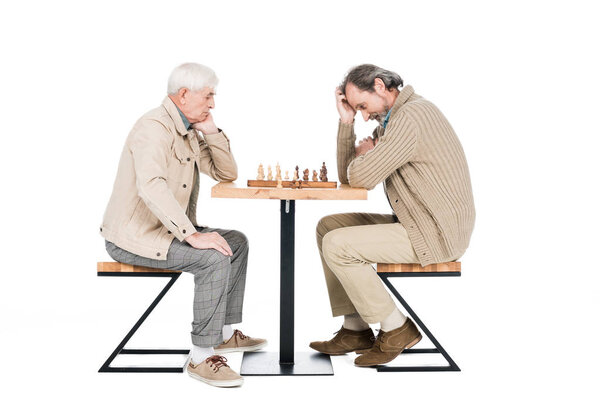 retired man thinking while playing chess with friend isolated on white