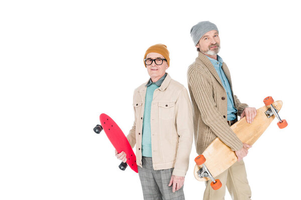 stylish senior men holding skateboards isolated on white