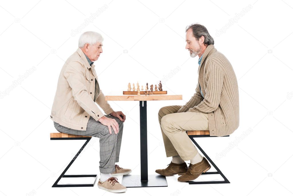 retired men playing chess while sitting isolated on white
