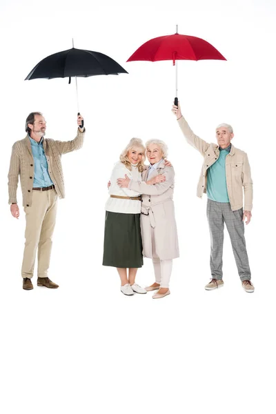 Senior Men Holding Umbrellas Women Standing Hugging Isolated White — Stock Photo, Image