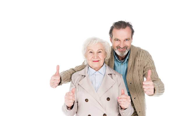 cheerful retired couple showing thumbs up isolated on white