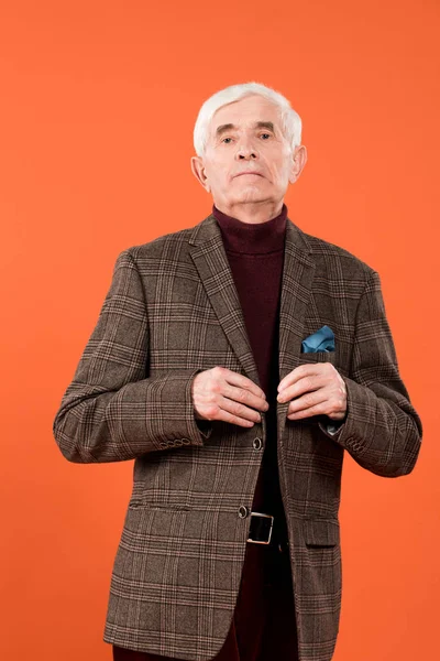 Trendy Senior Man Touching Jacket While Standing Isolated Orange — Stock Photo, Image