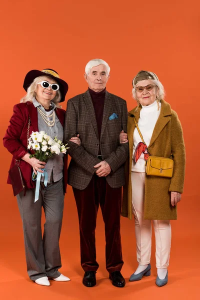 Stylish Senior Women Standing Retired Man Holding Flowers Orange Background — Stock Photo, Image