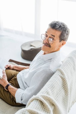 kitap ve evde gülümseyen bardakları neşeli emekli adam