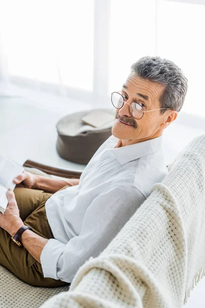 kitap ve evde gülümseyen bardakları neşeli emekli adam