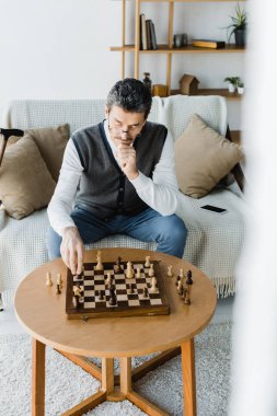 evde satranç tahtası seyir bardaklarda düşünceli emekli adam