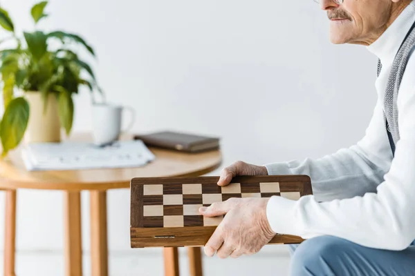 Cropped View Senior Man Sitting Holding Chess Board Home — Stock Photo, Image