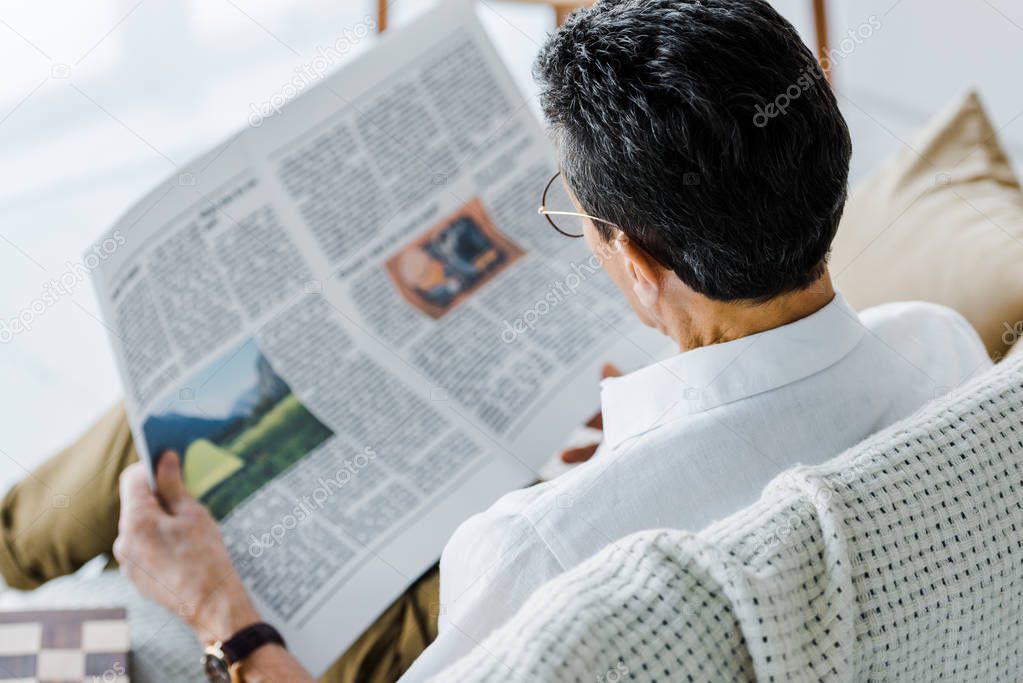 selective focus of man reading newspaper at home