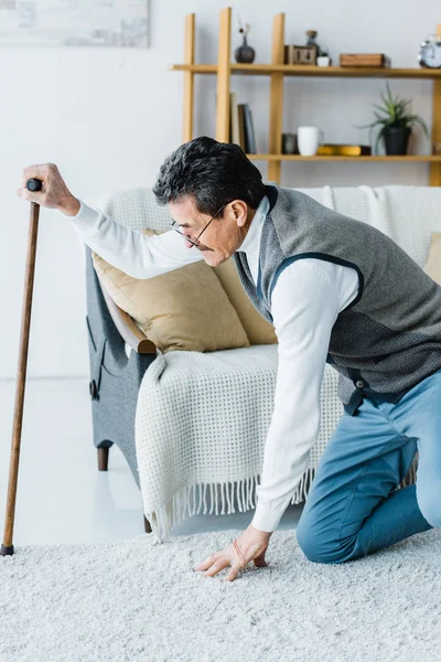 Uomo Anziano Occhiali Tenendo Bastone Passeggio Mentre Cerca Piedi Casa — Foto Stock