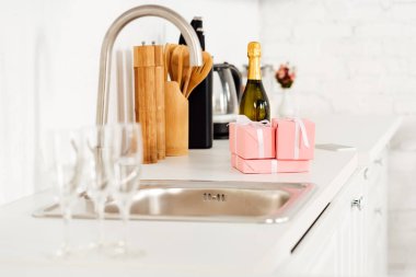 lavabo ve pembe hediye kutuları seçici odak şişe şampanya mutfak tezgahı ile