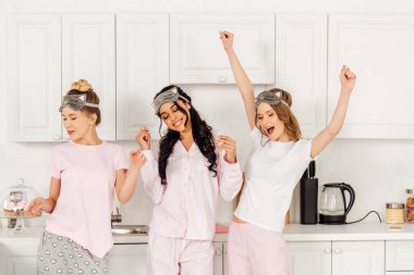 uyku güzel çok kültürlü kızlar pijama partisi sırasında mutfakta dans ve having fun maskeleri