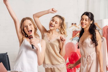 kıyafeti şarkı karaoke yatak odasında pijama partisinde gülümseyen çok ırklı kızlarda güzel