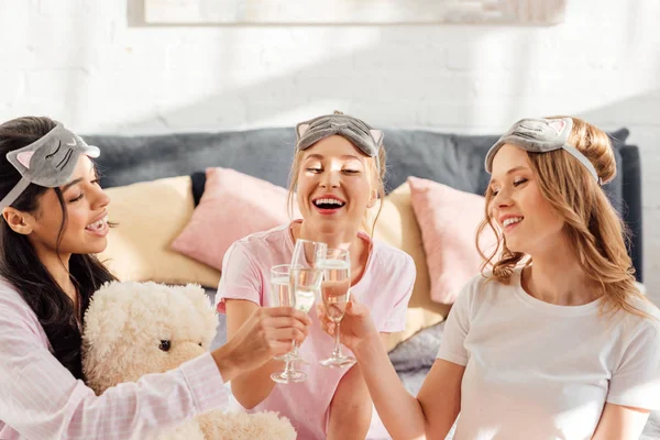 Schöne Fröhliche Multikulturelle Mädchen Schlafmasken Klirren Champagnergläser Während Pyjama Party — Stockfoto