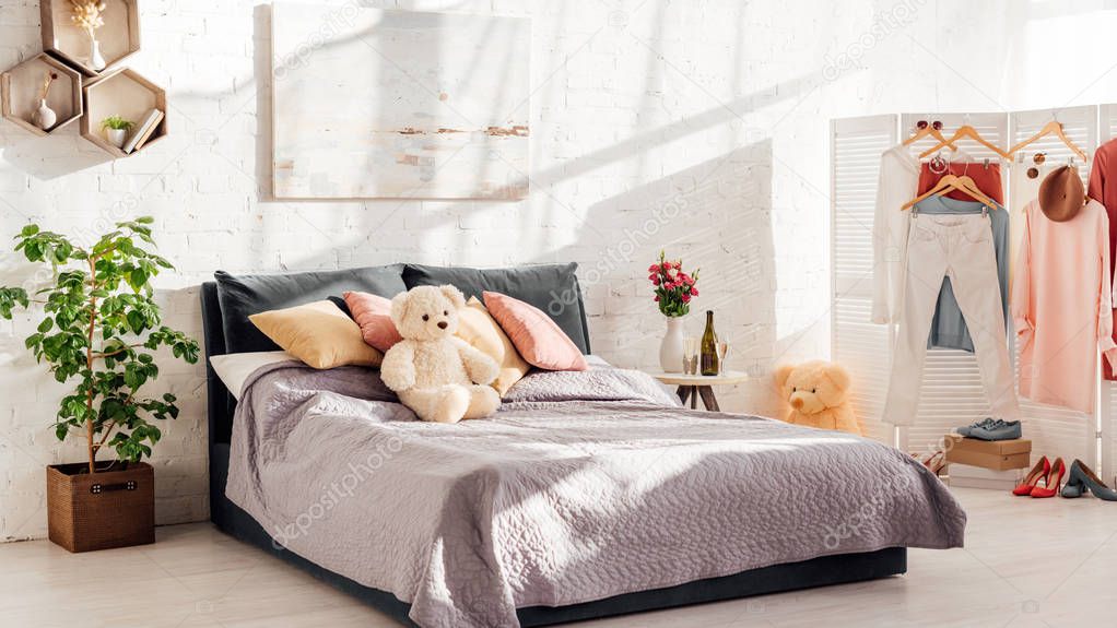 modern interior design of bedroom with teddy bear toys, pillows, plants and bed