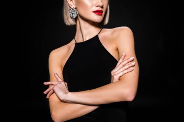 cropped view of glamour woman in earrings and black dress, isolated on black